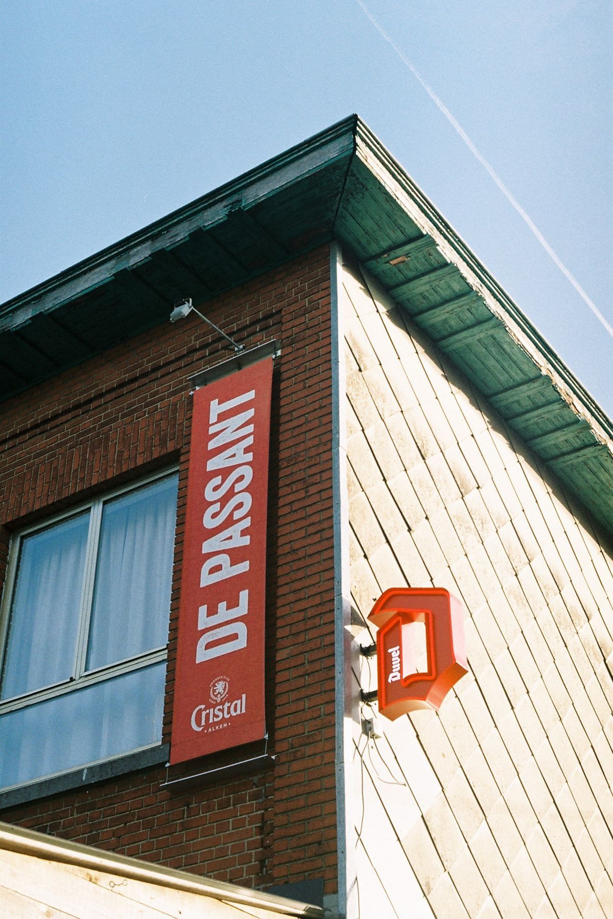 De gevel van De Passant met het rode uithangbord