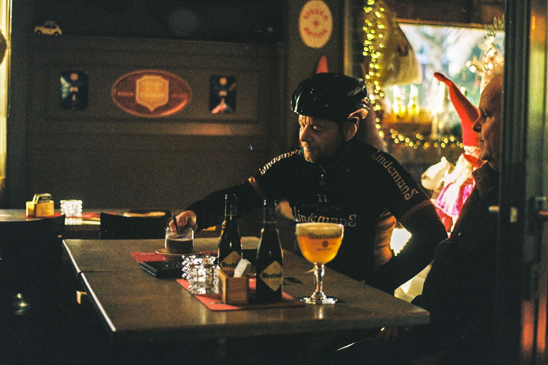 Wielrenner met een glas bier aan tafel